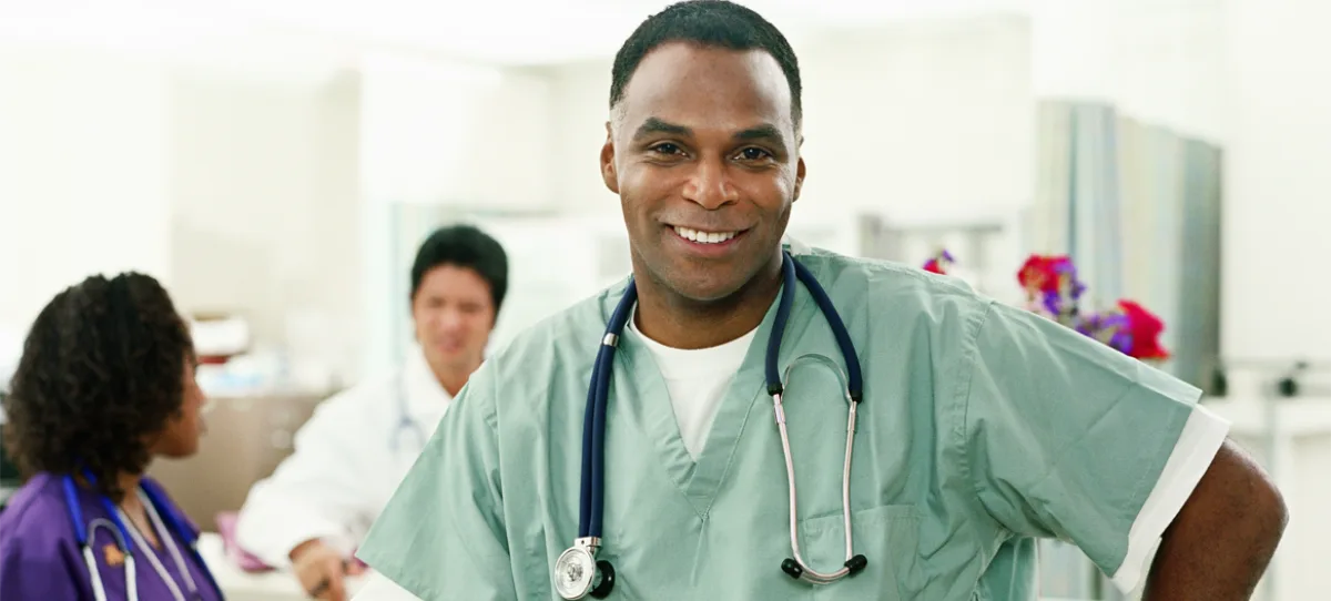 smiling doctor in scrubs in health care setting